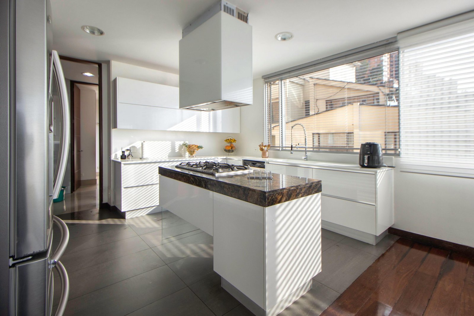 A contemporary kitchen with sleek white cabinets and ample natural light.